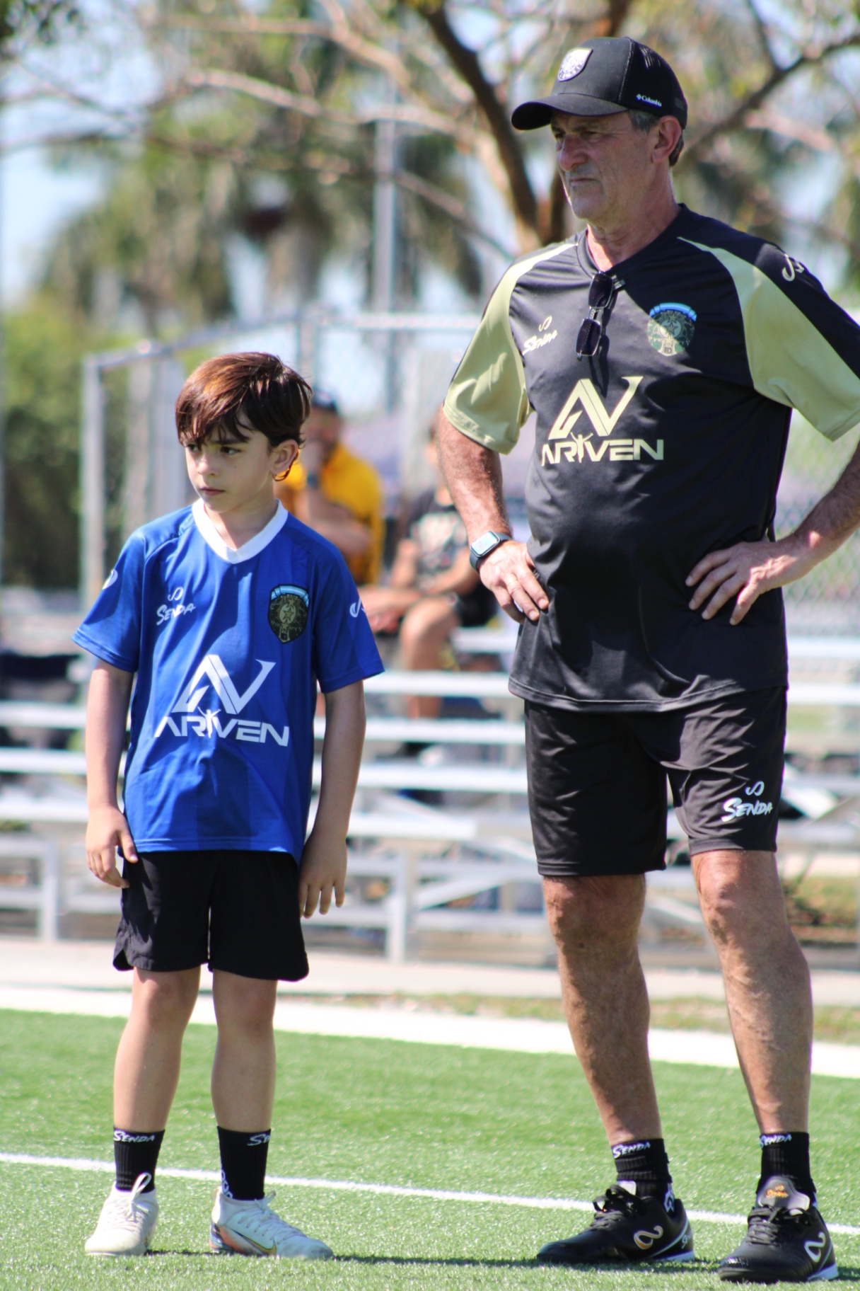Mario Kempes standing alongside a camp player during a session