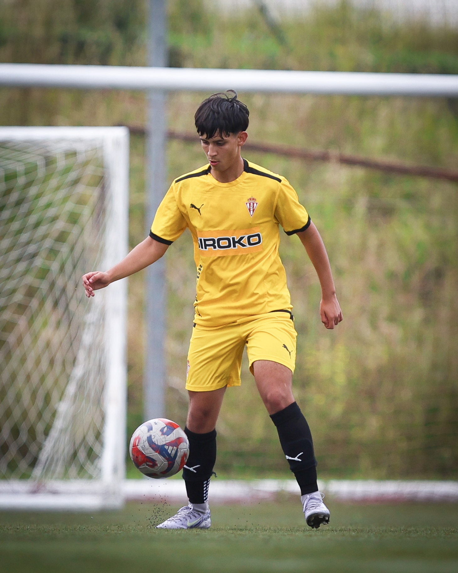 FFS player controlling the ball in a Sporting de Gijón match kit